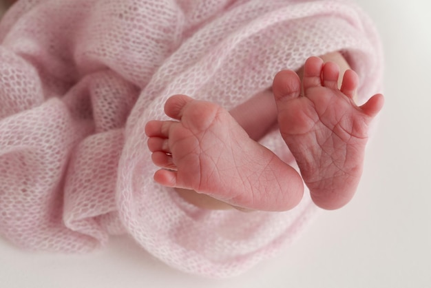 Closeup di piccole dita dei piedi nude carine tacchi e piedi di una neonata bambino piede bambino su rosa morbida coperta coperta dettaglio di un neonato gambe macro orizzontale foto di studio professionale