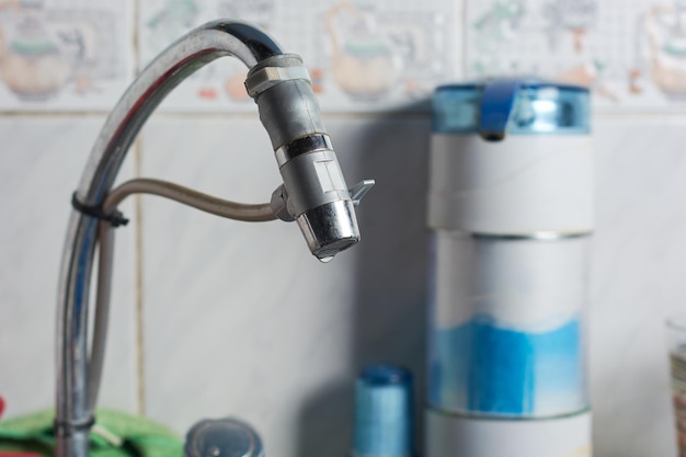 Closeup di un moderno purificatore d'acqua installato sul rubinetto d'acqua nella cucina di una casa