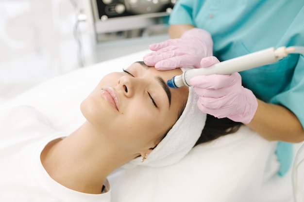 Closeup di una donna che si sottopone a un trattamento di peeling microdermabrasivo facciale femminile in bellezza cosmetica