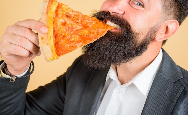 Closeup ritratto di fetta di pizza pranzo o cena uomo barbuto che mangia fetta di pizza uomo barbuto che mangia