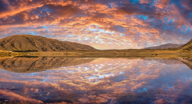 Cloudscape colorato vibrante al distretto dei laghi di Ashburton con un tramonto sbalorditivo riflesso sulla superficie dell'acqua