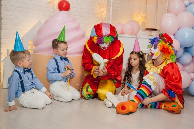 Clown boy e clown girl alla festa per bambini che si divertono con i bambini