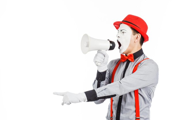 Clown MIME in possesso di un megafono L'espressione delle emozioni su uno sfondo bianco