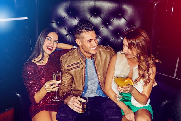 Club di amici e festa bevendo alcolici al concerto di un evento in discoteca o happy hour per la celebrazione del nuovo anno insieme Uomo e donna con un sorriso che si rilassa in discoteca e si diverte al rave o in discoteca