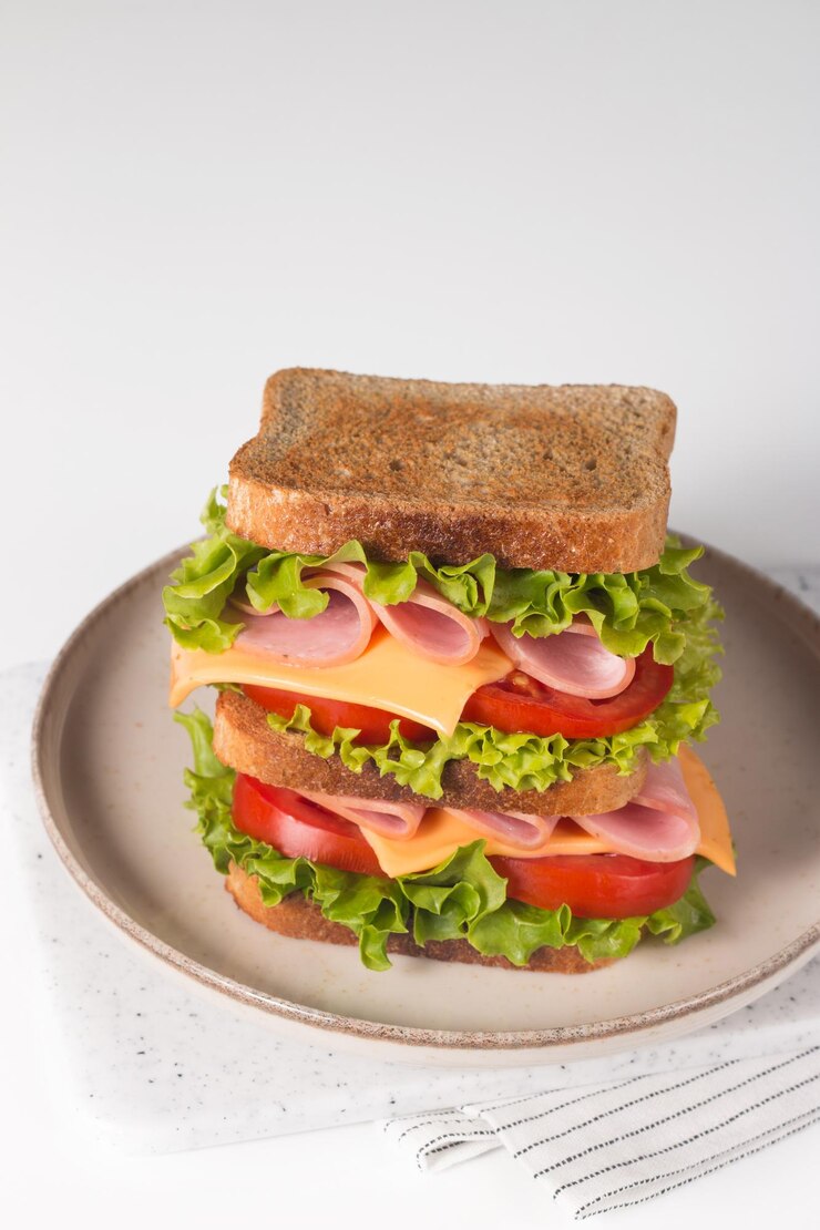 Club sandwich con prosciutto, formaggio, pomodoro e lattuga.