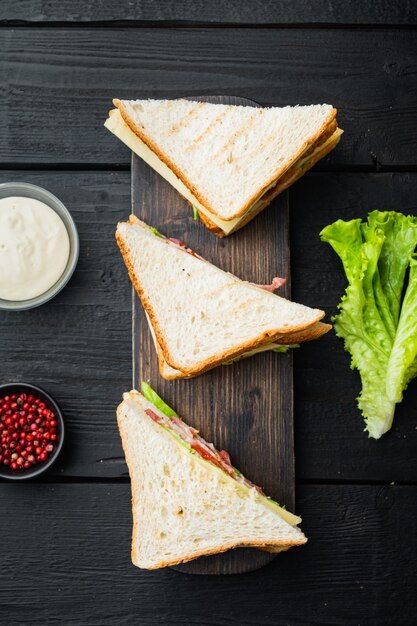 Club sandwich di tacchino fatto in casa, sul tavolo di legno nero, vista dall'alto