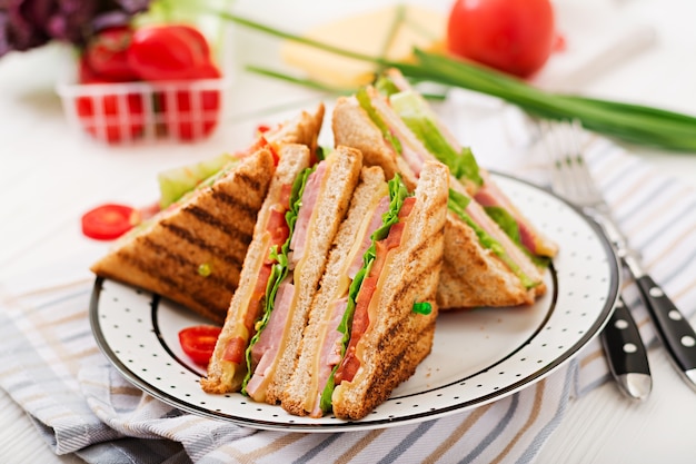 Club sandwich - panini con prosciutto, formaggio, pomodoro ed erbe aromatiche. Vista dall&#39;alto