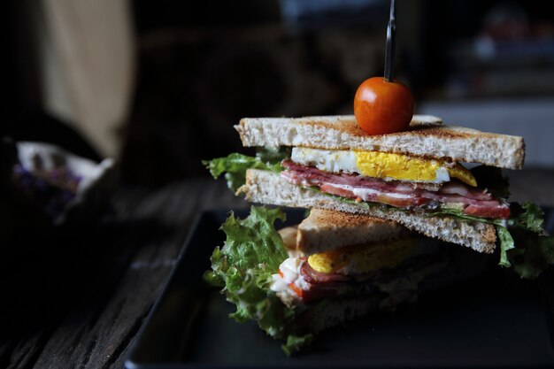 club sandwich su fondo in legno con luce mistica