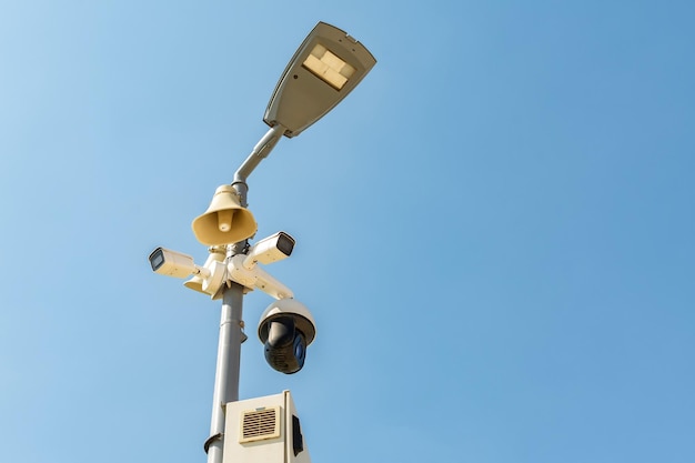 Cluster di telecamere di sicurezza su un lampione in un parco pubblico sullo sfondo del cielo con spazio di copia