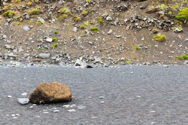 Cobble sulla spiaggia di Reynisfjara vicino al pendio del monte