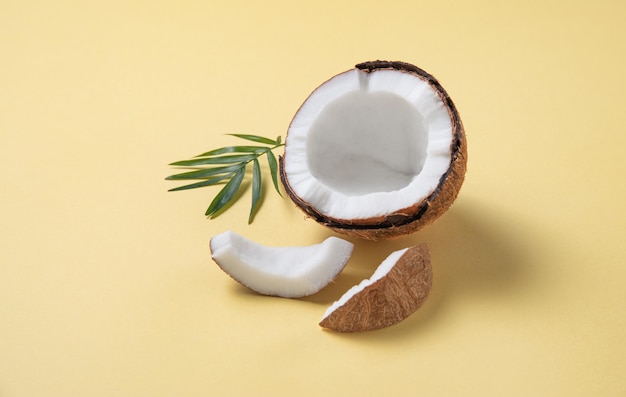 Cocco fresco e fette su sfondo giallo. Cibo sano e vegano. Copia l'immagine dello spazio