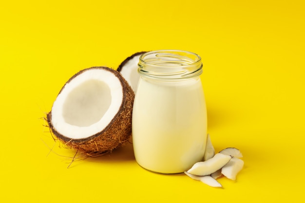 Cocco fresco e latte di cocco su sfondo giallo