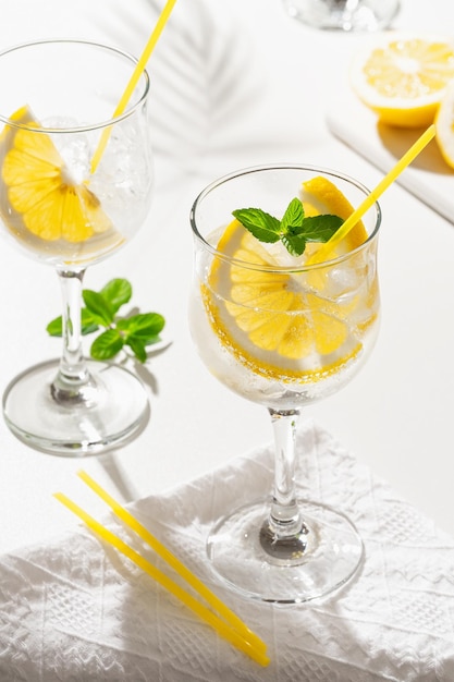 Cocktail al limone con uno spumante con ghiaccio nel bicchiere di vino isolato su bianco