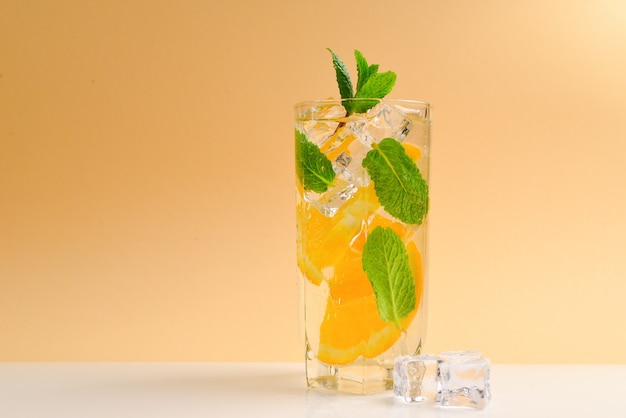 Cocktail al limone e menta su superficie beige