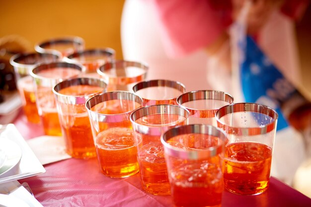 Cocktail alcolici arancione brillante in fila Impostazione su un tavolo da banchetto per catering Concetto di festa e celebrazione delle vacanze Spazio di copia Foto di alta qualità