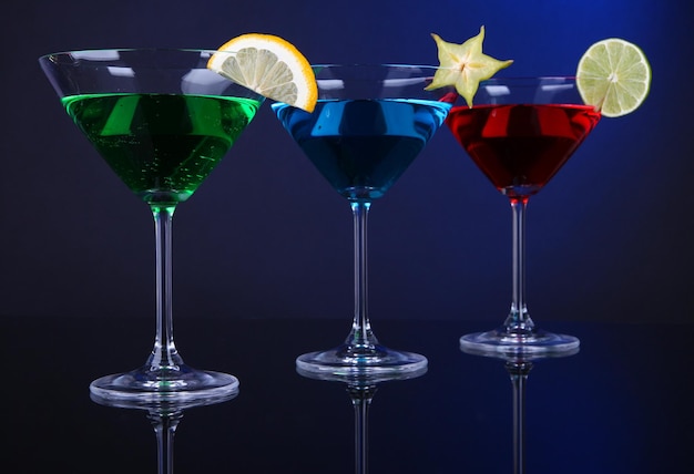 Cocktail alcolici in bicchieri da martini su sfondo blu scuro