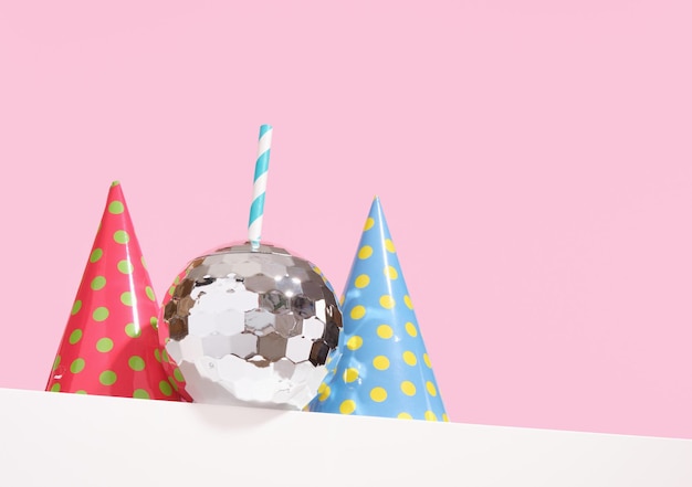 Cocktail alcolico con una cannuccia a forma di palla discoteca a specchio e cappelli creativi a colori Copiare spazio per il testo