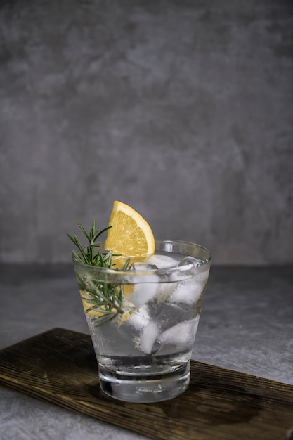 Cocktail alcolico gin tonic con limone, rosmarino e ghiaccio