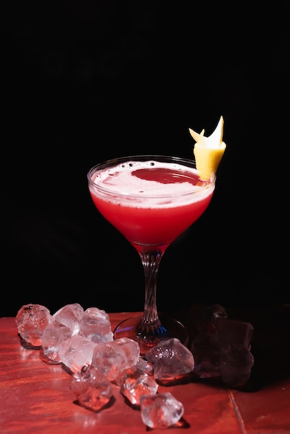 Cocktail alcolico rosso al bar decorato con limone e ghiaccio Il barista prepara le bevande per gli ospiti Vita notturna Vita da club Ottima porzione di cocktail Cocktail fantastici