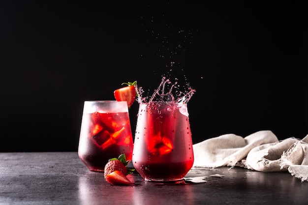 Cocktail alla fragola che spruzza in un bicchiere