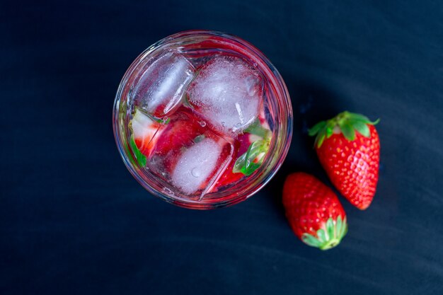 Cocktail alla fragola con fragola su uno sfondo nero