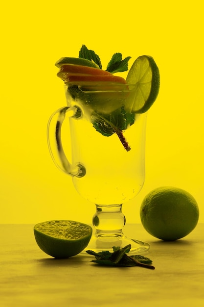 Cocktail analcolici con acqua infusa di agrumi con arancia limone e lime su sfondo colorato Rinfrescanti cocktail estivi Primo piano