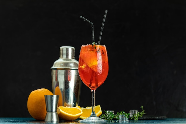 Cocktail aperol spritz in un grande bicchiere di vino con gocce d'acqua su sfondo scuro Cocktail alcolico estivo con fette d'arancia Cocktail italiano aperol spritz su tavola di ardesia Bevanda alla moda