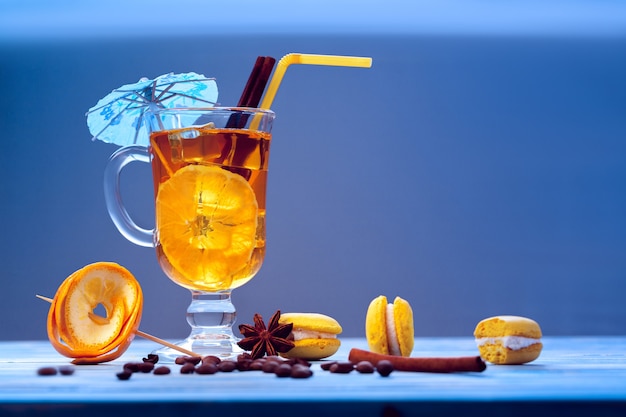 Cocktail arancione con ghiaccio su un tavolo blu