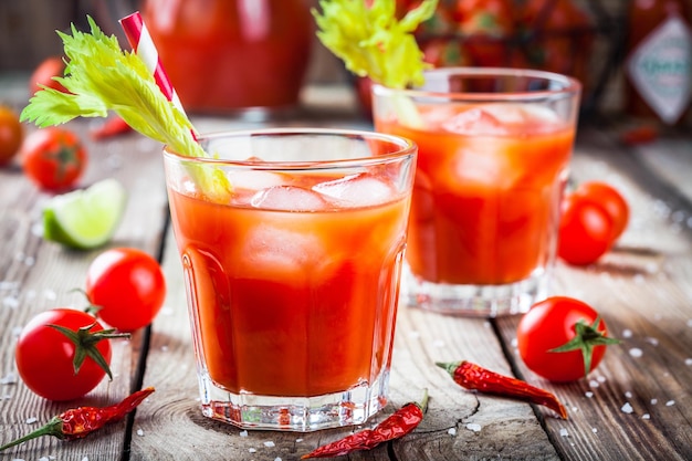 Cocktail Bloody Mary con ghiaccio in bicchieri su un tavolo di legno