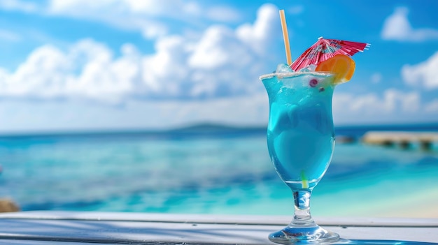 Cocktail blu hawaiano su un tavolo di legno bianco con mare blu e cielo sullo sfondo