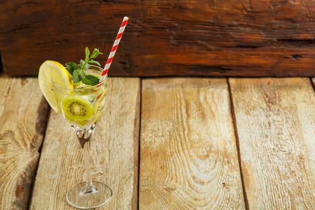 Cocktail con kiwi menta e limone in un bicchiere su un tavolo di legno. copia spazio. Foto orizzontale