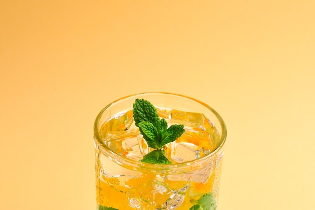 Cocktail con limone e menta su fondo beige. Copia spazio.