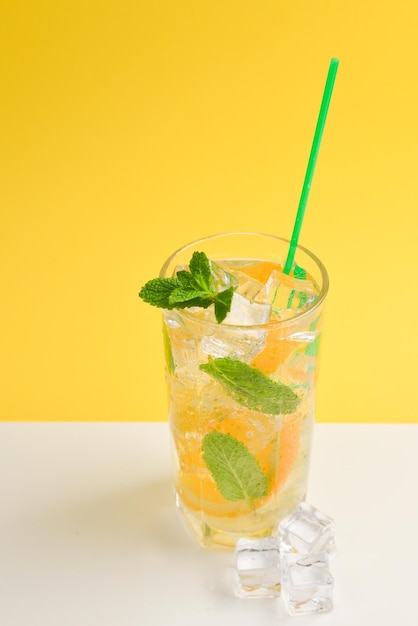 Cocktail con limone e menta su sfondo giallo Copia spazio
