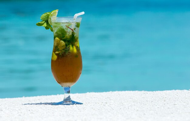 Cocktail con sfocatura spiaggia sullo sfondo