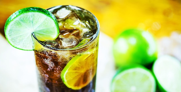 Cocktail Cuba Libre con menta ghiacciata e vassoio su tavolo di legno