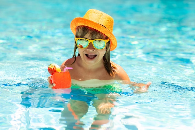 Cocktail da bere per bambini in piscina Stile di vita attivo e sano nuotare attività di sport acquatici durante le vacanze estive con bambino Moda estate bambino ragazzo in cappello e occhiali da sole