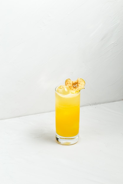 Cocktail dell'alcool di giallo della frutta fresca in un highball