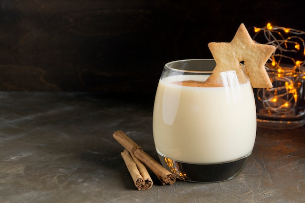 Cocktail dello zabaione e biscotti della stella su fondo nero.