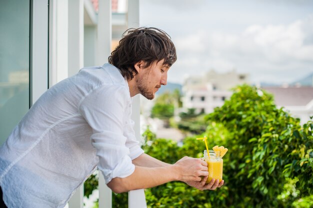 Cocktail di ananas con una fetta di uomo delle mani sulla terrazza. Concetto tropicale