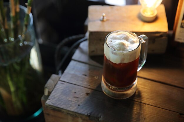 Cocktail di caffè con chicco di caffè e rosmarino in cima con fondo di legno