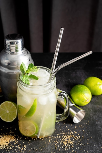 Cocktail di caipirinha fresco estivo su sfondo nero a tendina