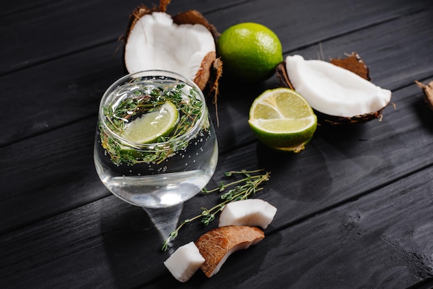 Cocktail di cocco su uno sfondo di legno scuro acqua di cocco con calce