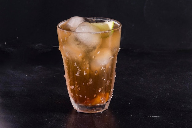 Cocktail di cola al rum su sfondo scuro