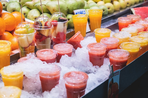 cocktail di frutta fresca e fette di vari frutti in un bicchiere su un bancone nel mercato