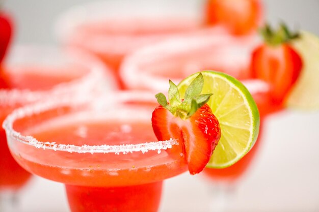 Cocktail di margarita alla fragola fresca guarnito con fragole fresche e lime.