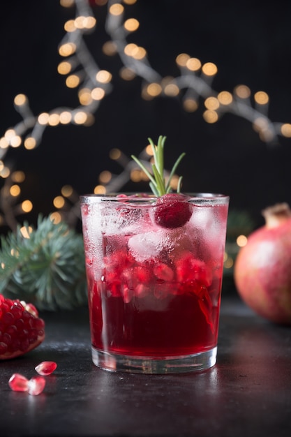 Cocktail di Natale al melograno con spumante guarnito con rametto di rosmarino