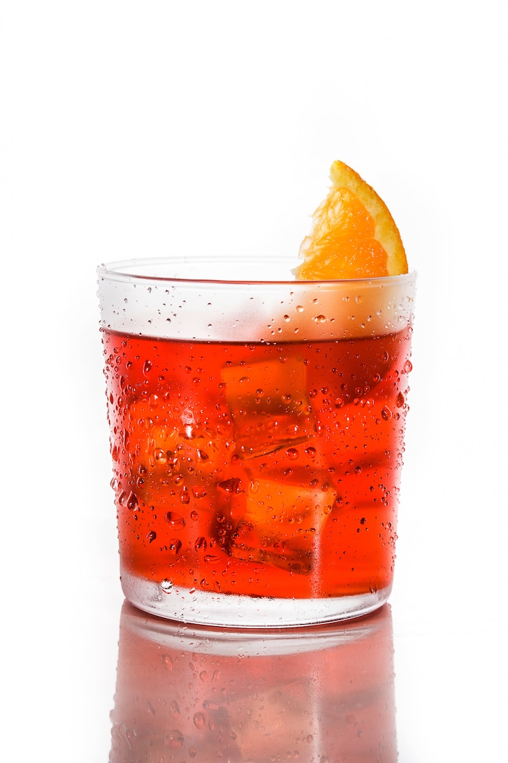 Foto cocktail di negroni con il pezzo di arancia in vetro isolato su bianco