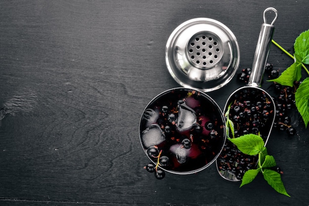 Cocktail di ribes nero fresco con ghiaccio su fondo di legno Vista dall'alto Spazio libero