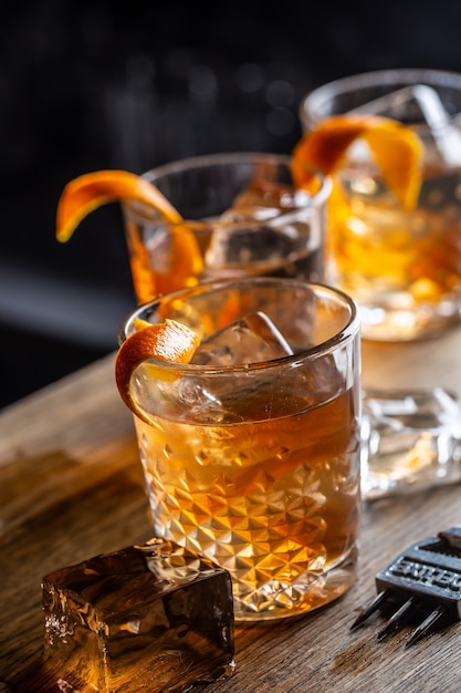 Cocktail di rum vecchio stile su ghiaccio con contorno di scorza d'arancia.