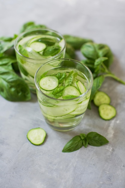 Cocktail di verdure fresche estive verdi Mocktail con foglie di basilico e cetriolo Bevanda fresca verde su sfondo grigio